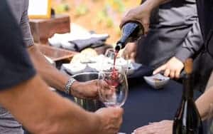 wine being poured into wine glass on table