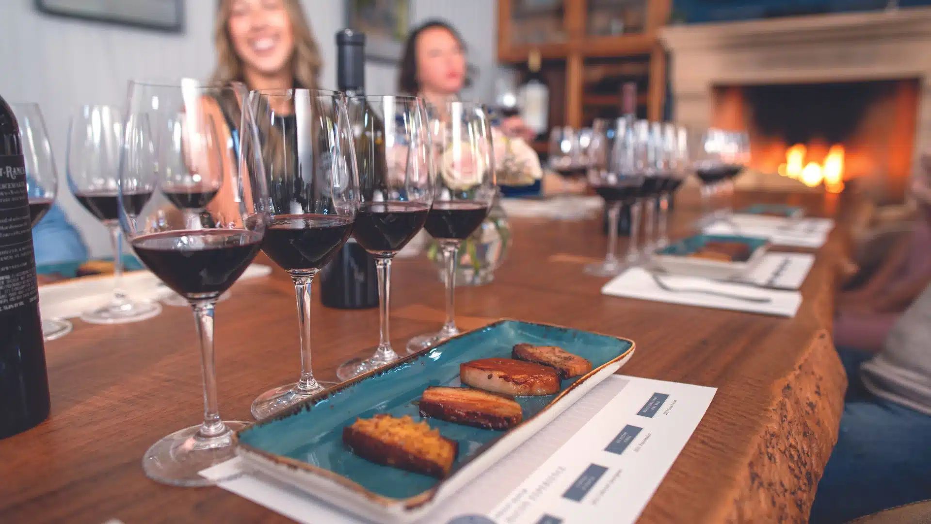 Priest Ranch outdoor table with bacon tasting platter and wine glasses on wood surface
