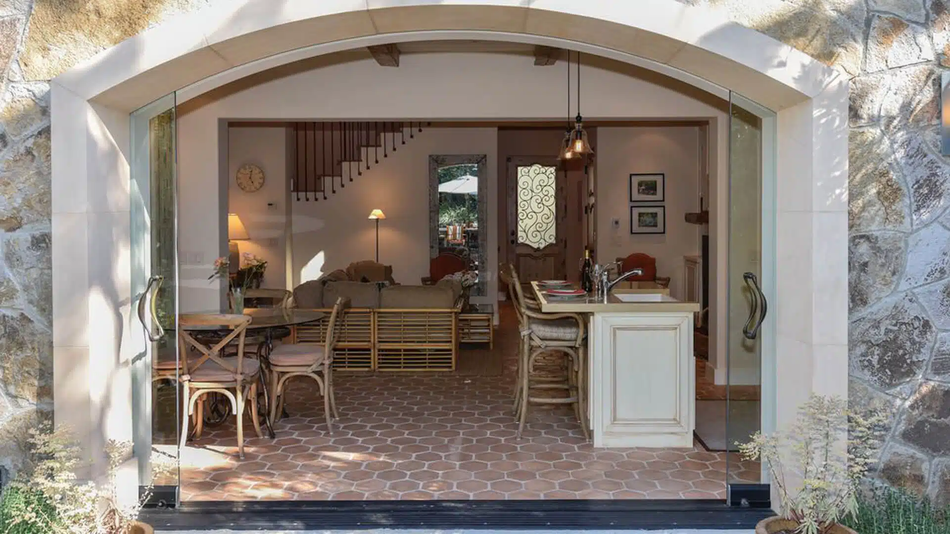 Cozy open-concept living space with rustic tile floors and a view through large glass doors into the living room.