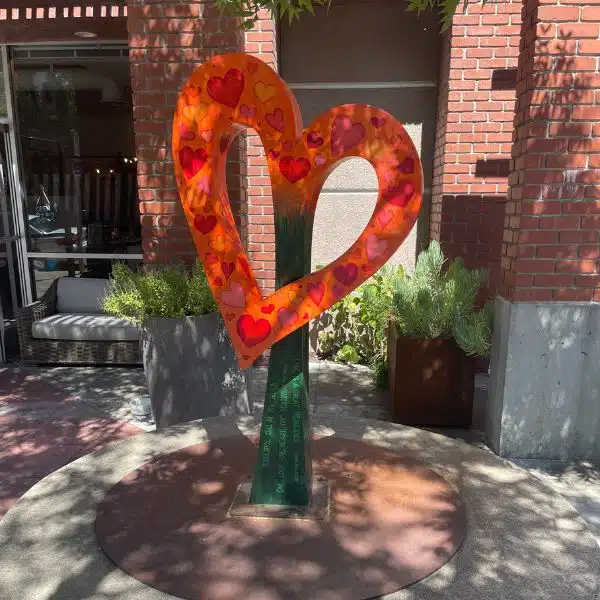 Let Love Bloom sculpture of a heart painted orange and green