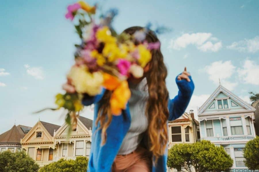 Women with flowers in front of face