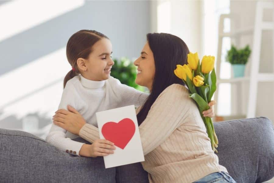 Mother and daughter with yellow flowers and a heart card