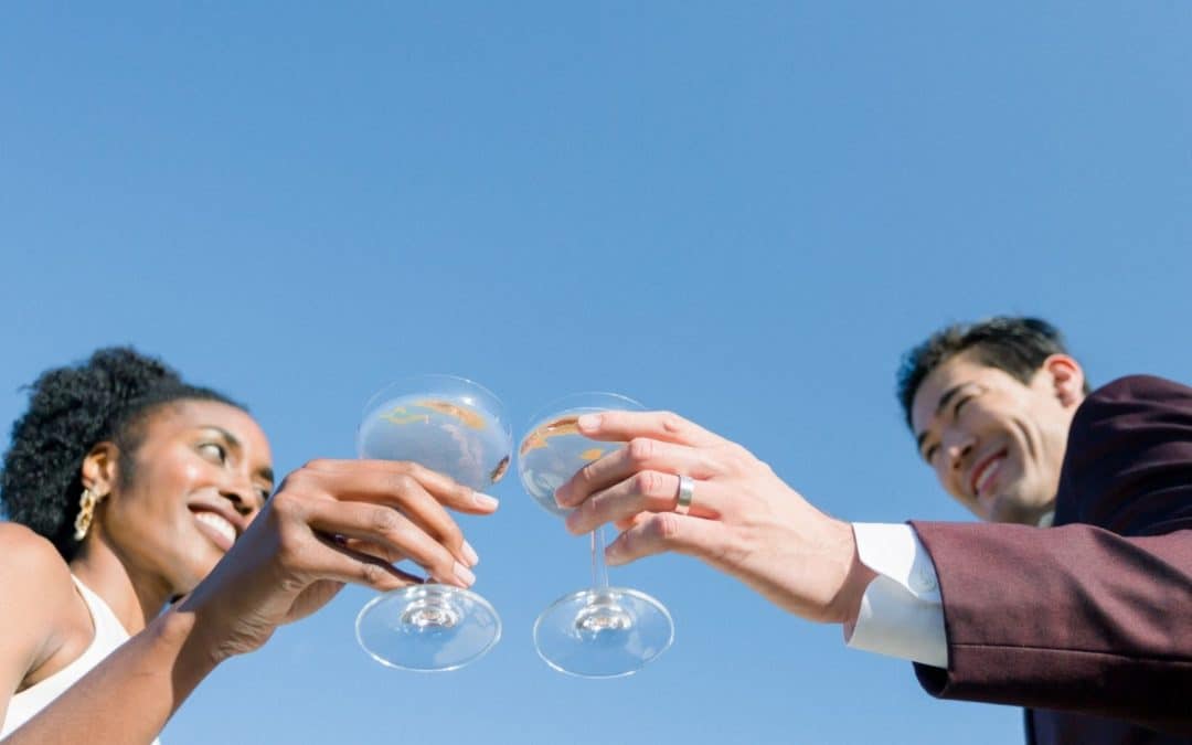 black women and asian man clicking champagne glasses