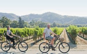 man and women on bikes with vineyards behind them