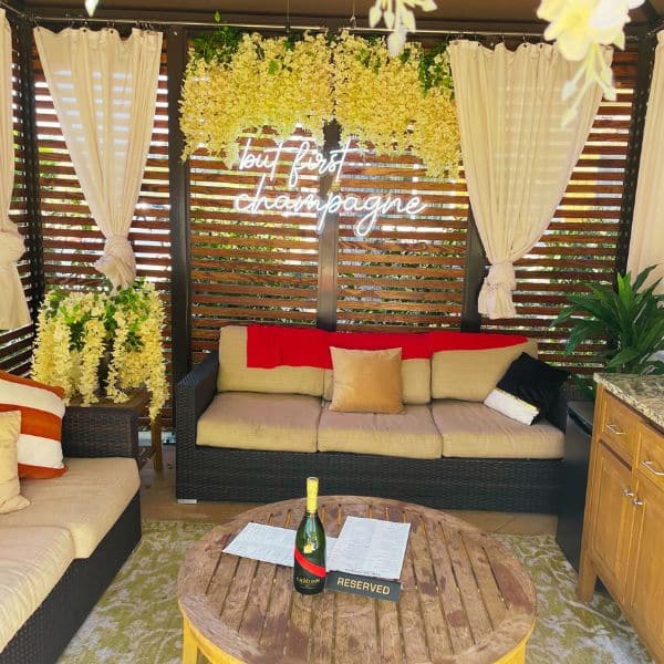 Inside a pool cabana with couches and champagne