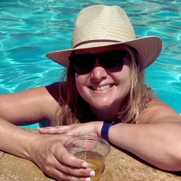 blonde girl in a pool with a hat