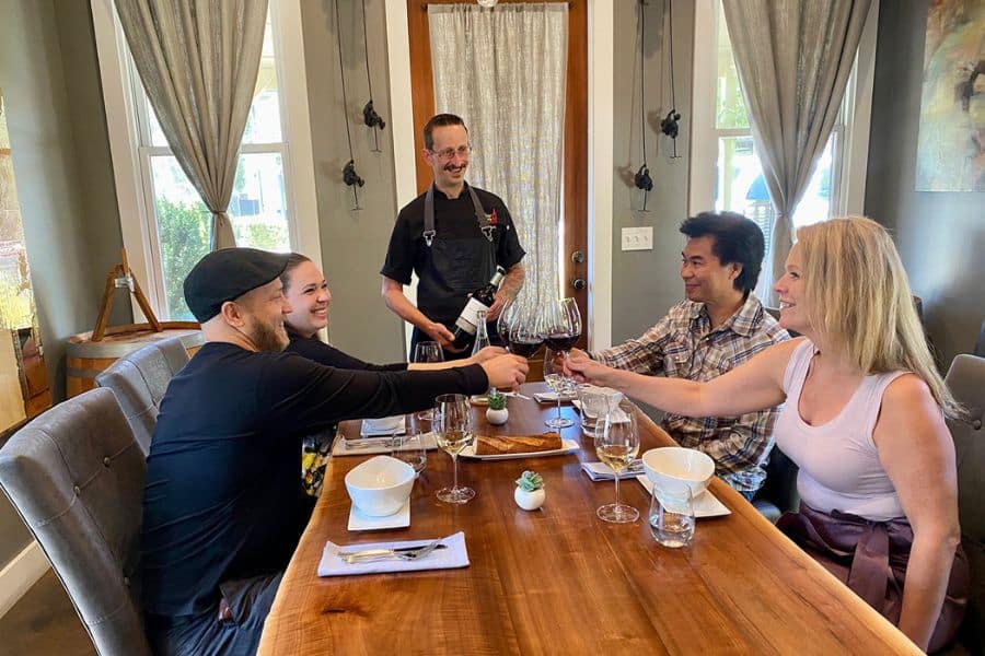 Four people with wine and a chef at Jessup Cellars