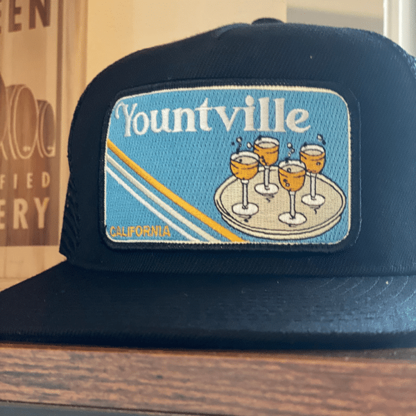 Flat brimmed hat with Yountville Patch featuring champagne classes