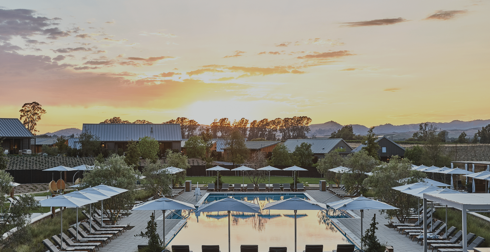 A view of Stanly Ranch Resort, loverlooking the pool with vineyards in the background