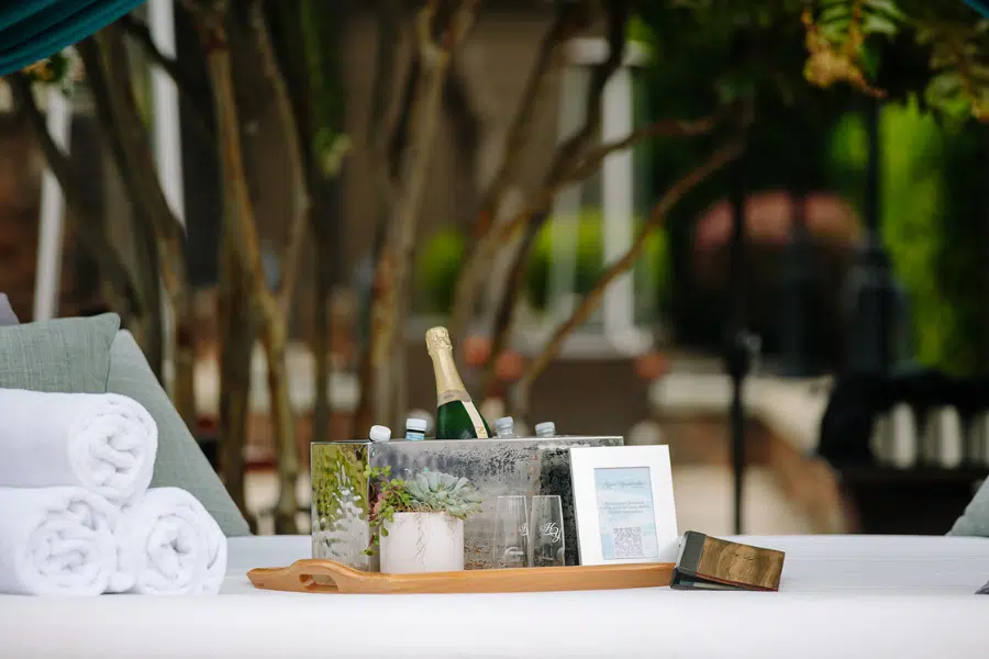 A cabana bed with a tray of wine and food