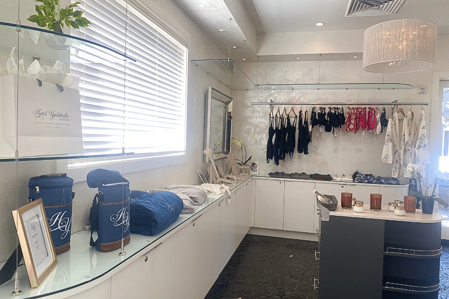 Boutique shelves lined with jewelry, blankets, swimwear and other spa products