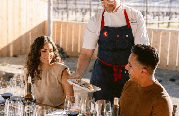 couple sitting at table being served wine