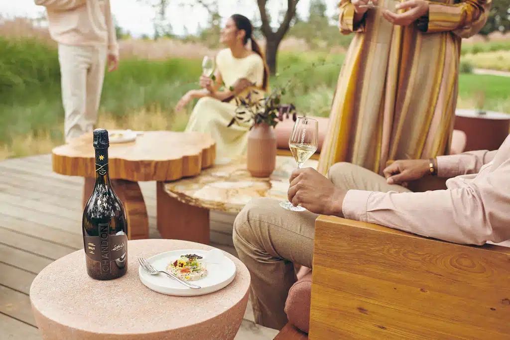 man sitting outside with people drinking wine