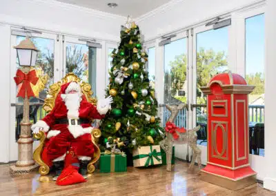 Santa sitting by christmas tree