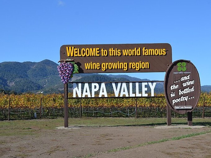 welcome napa valley sign with vineyards behind