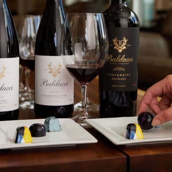 wine glass next to plates of chocolates