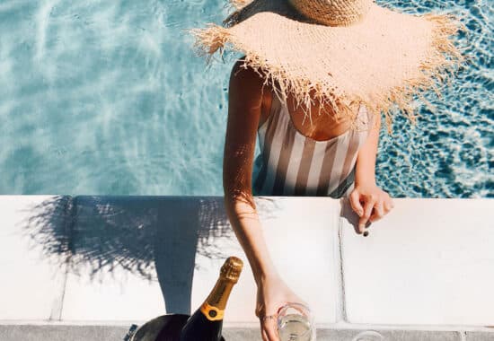 woman in pool with champagne drink