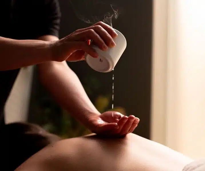 woman pouring candle wax into hand