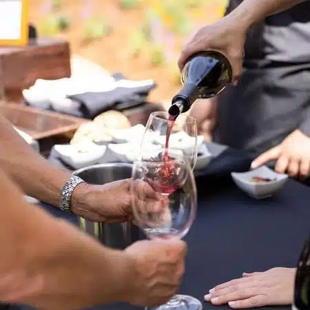 wine being poured into wine glass on table