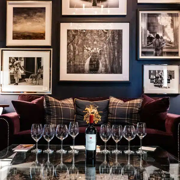 wine bottle with wine glasses on each side on table in front of couch