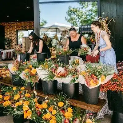 people sitting around tables under big tent