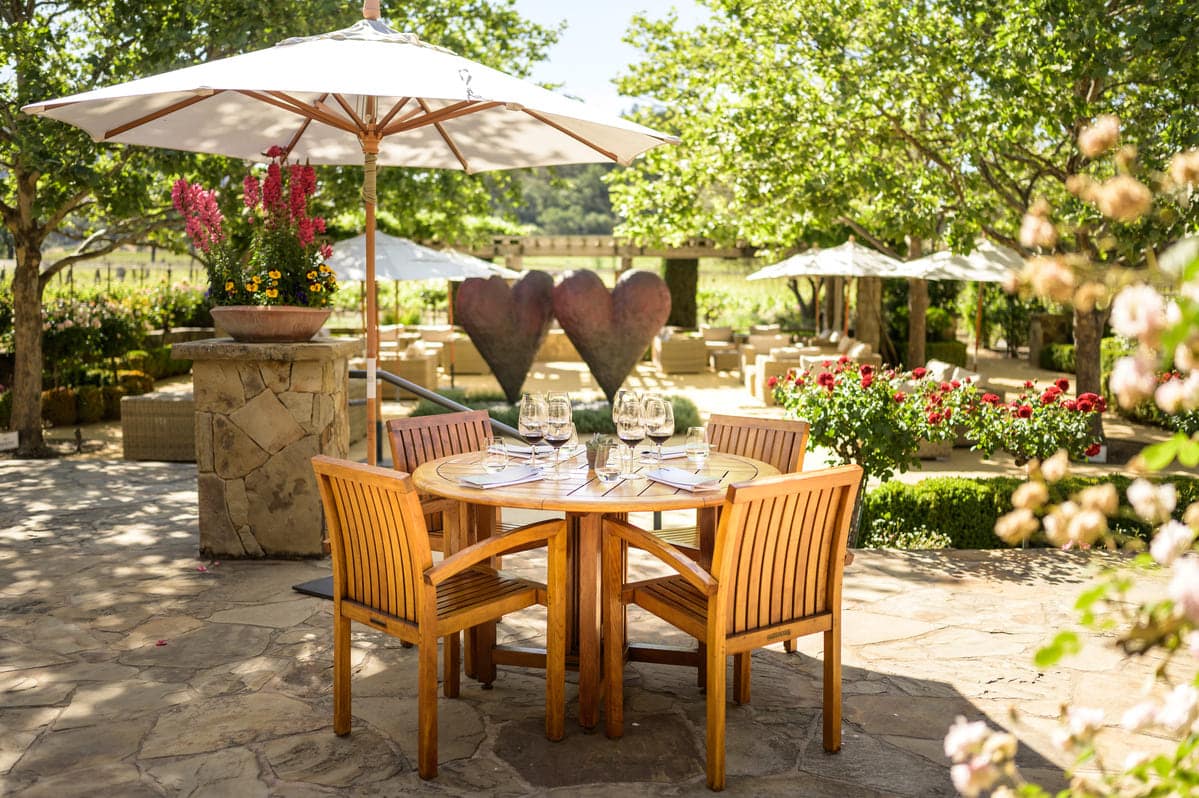 10-24 Classic Rock, 100 Point Wines, and Vineyard Views Yountville’s Cliff Lede Vineyard header table on patio for wine tasting
