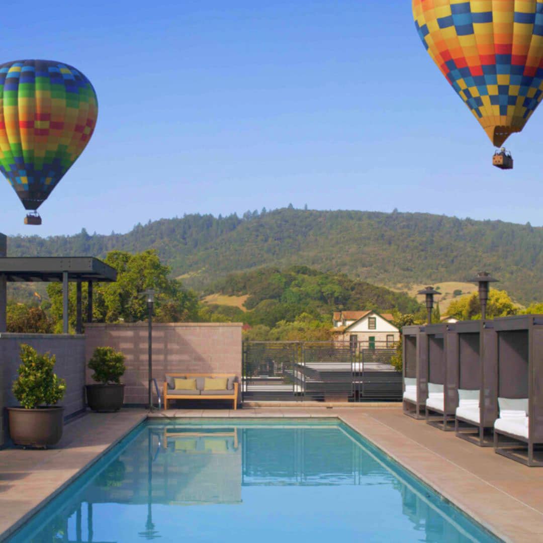 view of hot air balloons from a pool in Yountville