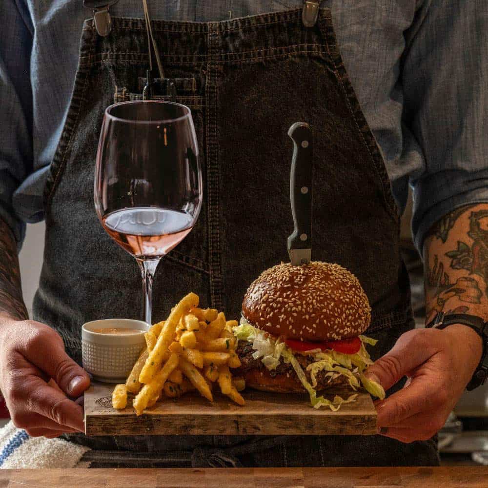 wine, fires with dipping sauce and burger being served