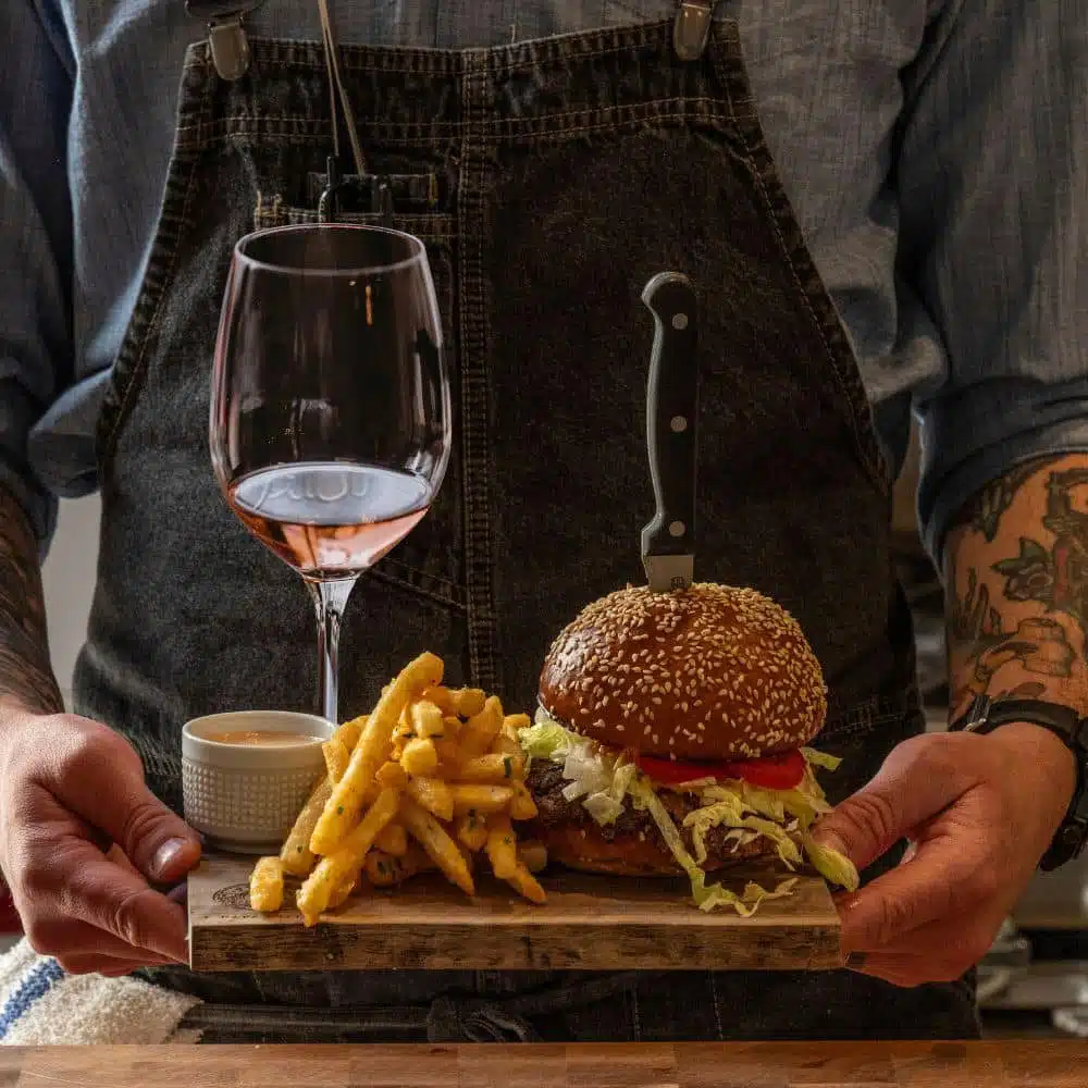 wine, fires with dipping sauce and burger being served