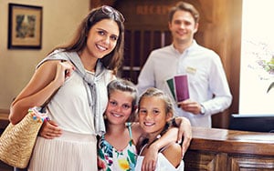 family checking into hotel reception